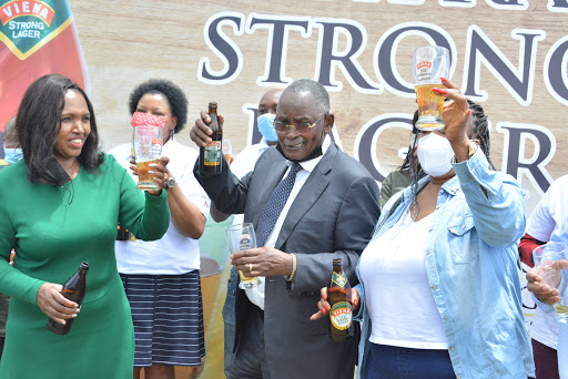 The CEO Keroche Breweries Tabitha Karanja (L) and the Chairman Joseph Karanja (C) join traders in launching Vienna Ice Strong Lager at their Naivasha based factory on 27/4/21. The product that has a ten percent alcohol content is expected to generate Sh1B annually to the exchequer.