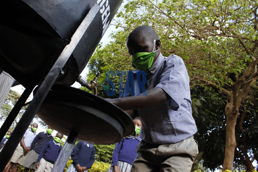 A grade four pupil washes hands before heading to a classroom in Kangemi Primary following the re-opening of Schools on October 12,2020.Photos/Enos Teche