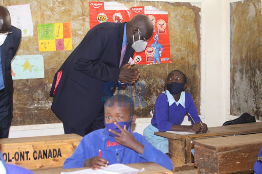 Education CS George Magoha speaks to a grade 4 pupil Cate Atieno at Olympic Primary School, Kibra on October 12, 2020/ANDREW KASUKU