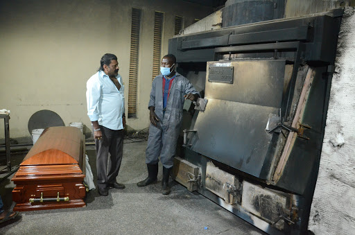 Harish Patel looks on as a  worker at the Hindu crematorium opens the furnace in Kariokor, Nairobi, on April 25, 2021.