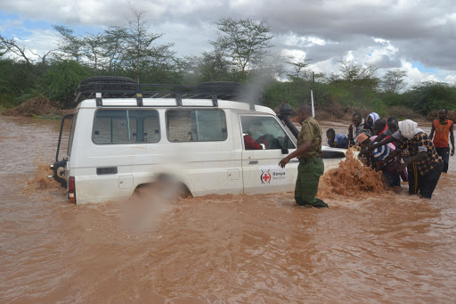 A police officer helps members of the public  push a vehicle belonging to the Kenya Red Cross in Dukanotu on April 27