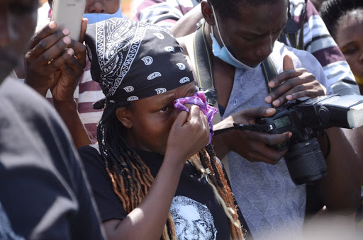 A mourner is overcomed with grief after viewing the body of Mzee Njenga Mwenda during the burial at Langata Cemetery