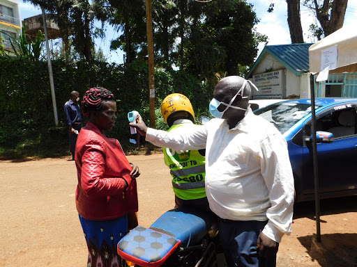 A health officer takes temperatures to people attending the Meru Level 5 hospital, March 21, 2020