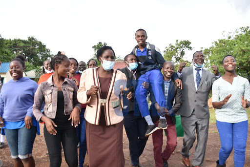 Henry Madaga of Maranda School who scored an A of 84 points in KCSE is joined by the teachers and alumni of Kosao Primary School in Kisumu on May 10, 2021. 