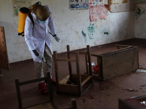 A community health volunteer fumigates a classroom at Milalani School for the Physically Handicapped and Mentally Challenged on April 6, 2017. 