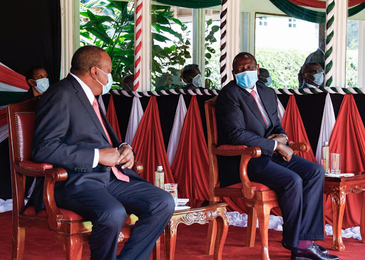 President Uhuru Kenyatta has a word with his deputy Dr. William Ruto during the 57th Madaraka Day Celebrations at State House Gardens, Nairobi.