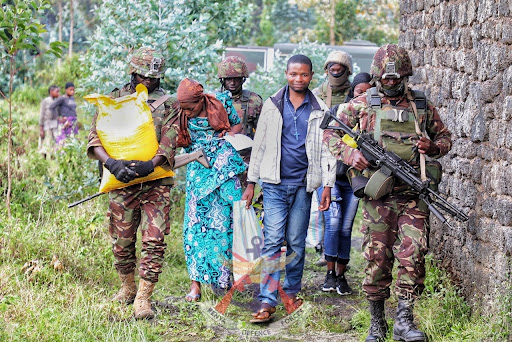 Kenyan soldiers under the EACRF escort a woman they helped deliver a baby back home in Kibumba on Thursday, May 25, 2023.