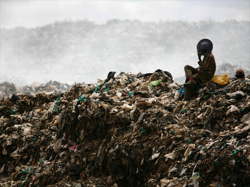 A boy sits on a pile of garbage at the Dandora dumpsite